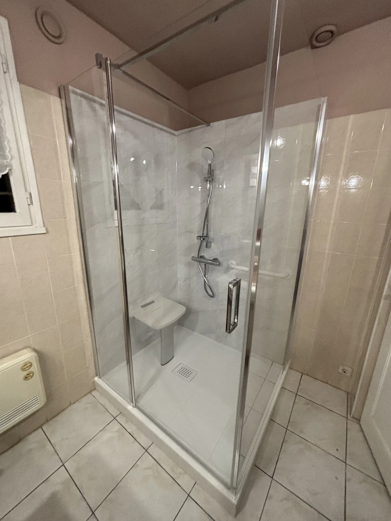 Douche sécurisée avec un habillage complet en dalles Dumawall Evora, parois vitrée avec porte pivotante