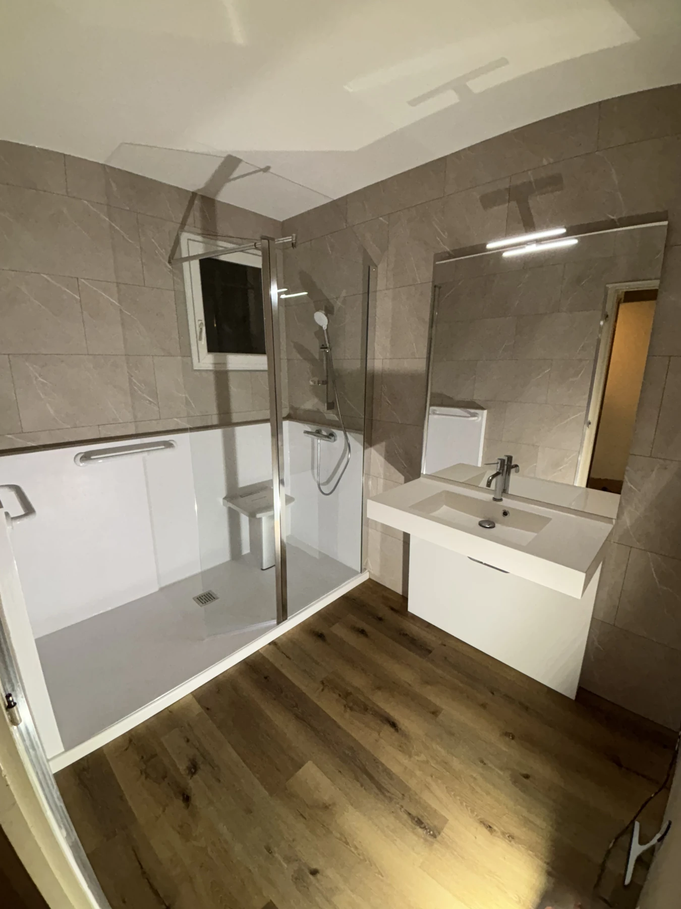 Salle de bain sécurisée, meuble Pmr vasque suspendu, sol antidérapant et habillage murs en dalles pvc
