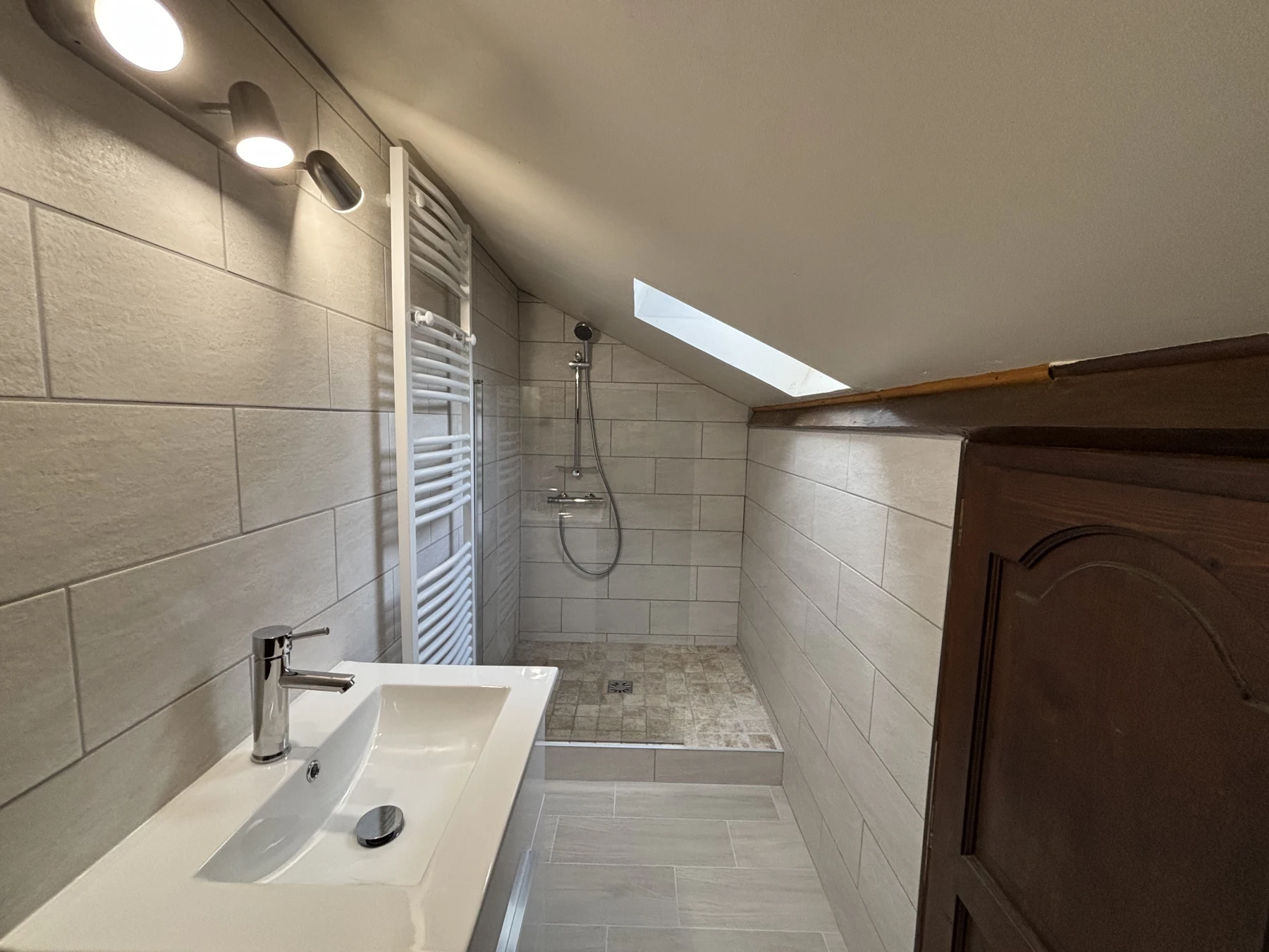 Douche à l’italienne en carreaux de travertin, pose de carrelage et faïence, changement meuble salle de bain et pose d’un sèche-serviette
